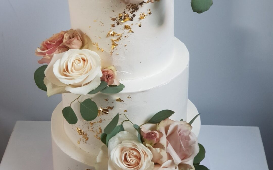 Creme Torte mit Blattgold und Blumen